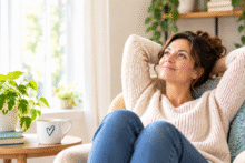 Woman relaxing comfortably in a sunny living room, enjoying a peaceful moment without feeling the need to be productive.